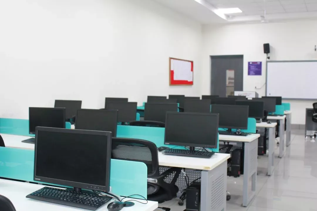 A computer lab on the Haldwani campus, rows of desktop machines at teal desks