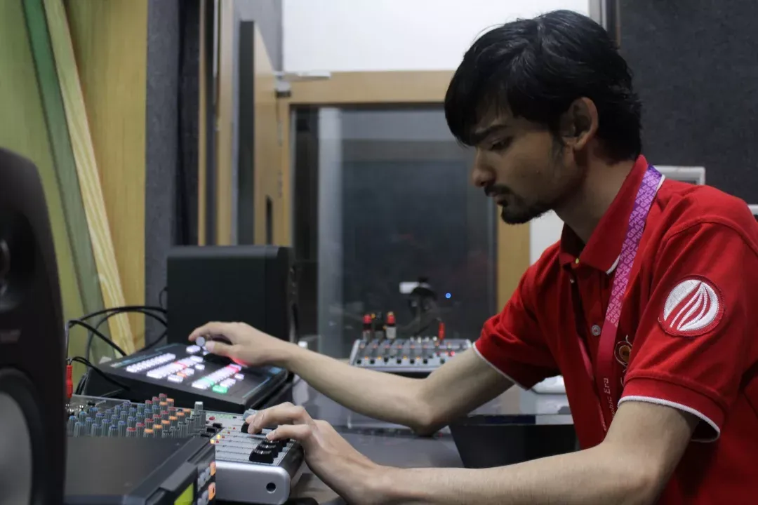 A student operating a vision mixer in the campus production control room